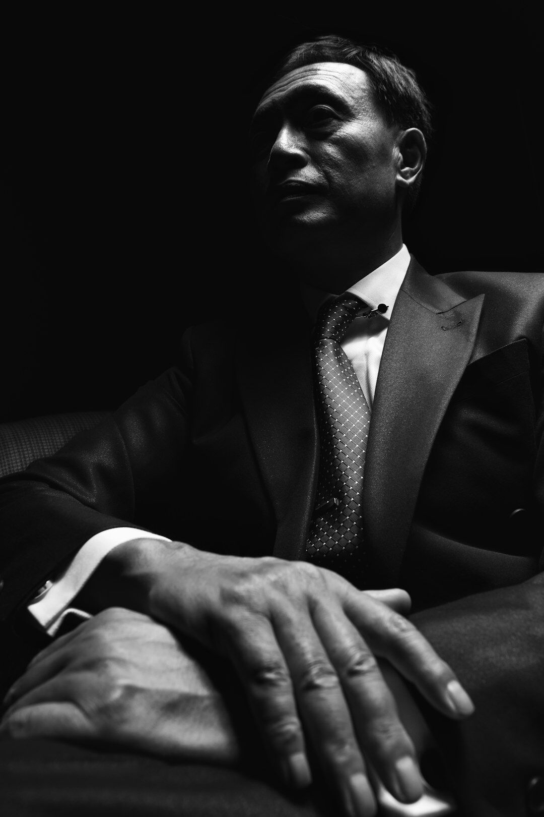 Fashion editorial photo of a man in a tailored suit adjusting his cufflink