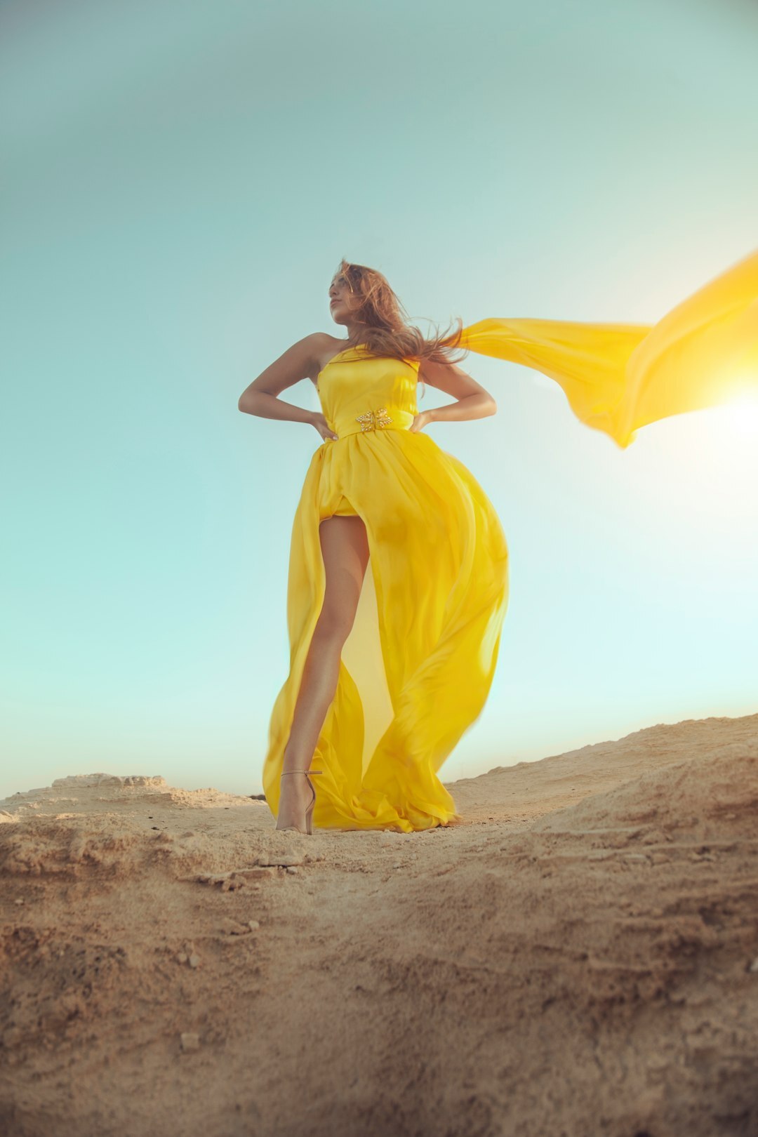 Fashion editorial photo of a woman in a flowing amber dress
