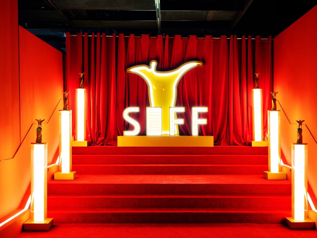 Elegant woman in evening gown walking a red carpet under warm lights